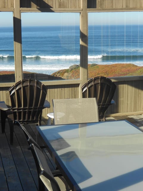 Waves crashing in front of house.