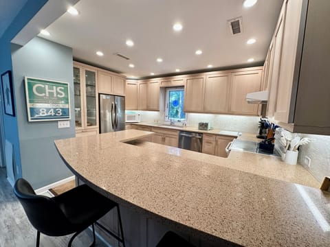 Large well-stocked kitchen with countertop bar.
