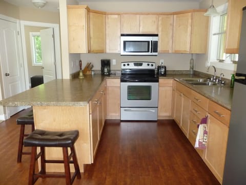 Modern kitchen with stove, microwave, refrigerator, coffee maker, and toaster
