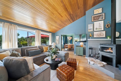 Light-filled living with vaulted ceilings, cozy fireplace, and seamless indoor-outdoor vibes, perfect for relaxing mornings or evenings by the fire.