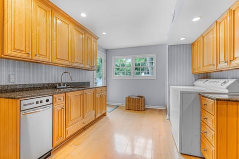 Laundry area just off the kitchen with washer, dryer, second fridge/freezer and access to pool and backyard
