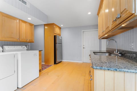 Laundry area just off the kitchen with washer, dryer, second fridge/freezer and access to pool and backyard