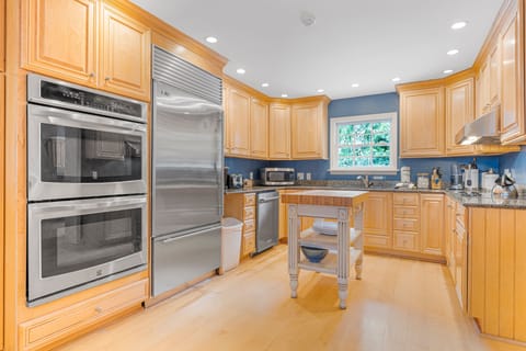 Full kitchen with view of pool, dual ovens, large refrigerator, microwave and coffee area