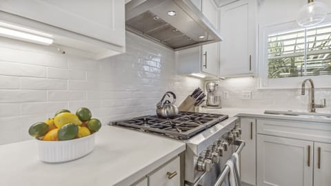 Kitchen features a 6 burner Wolf gas range and oven.