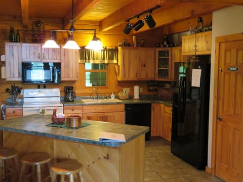 Fully equipped kitchen with pots, pans, dishes, glasses, utensils, and more