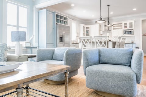 Open living room with large chairs to enjoy the company weather in the kitchen or around the coffee table for