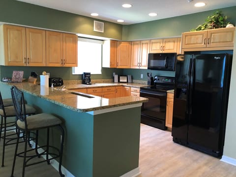 Kitchen with bar stools and all cooking supply needed included