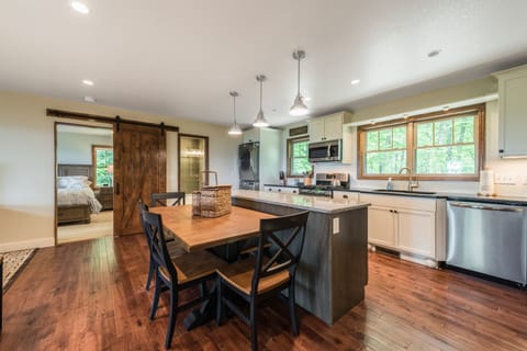 Kitchen island with dining table  - barn door to bedroom in background