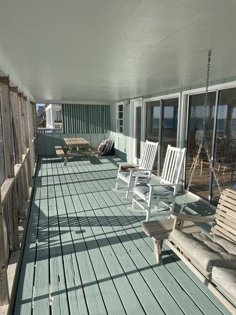 Oceanfront screen porch with fresh paint, picnic table, rockers and porch swing
