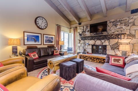 Cozy living room with wood fireplace, sofa bed, and smart TV.