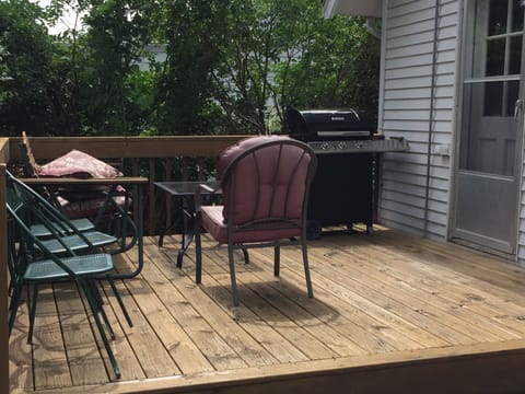 Deck with gas grill, glider and chairs.