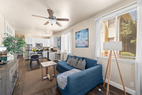 Sunlit living room flows seamlessly into a fully equipped kitchen and dining space.