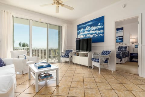 Relax in your bright coastal living room with stunning balcony views and crisp white furnishings.