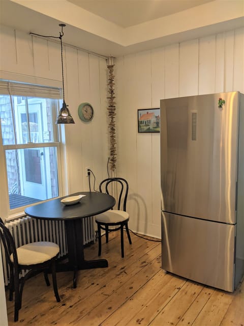 Kitchen table with a view to the patio. New stainless steel refrigerator.