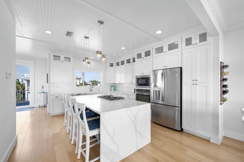 Chef's kitchen with large island and stainless appliances including gas cooking.