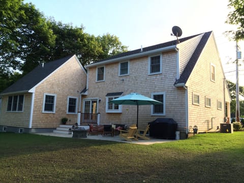 Rear view of the house with deck, patio, grill, adirondacks,two tables 12 seats.