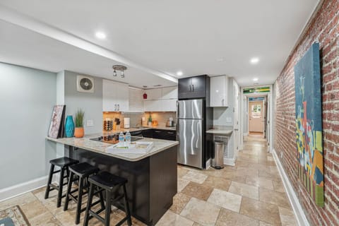 Modern kitchen with brick accent wall, and sleek finishes.