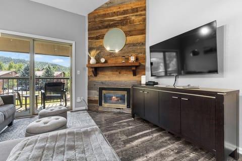 Gas Fireplace on Reclaimed Wood Accent Wall - Large HDTV mounted above espresso-colored credenza