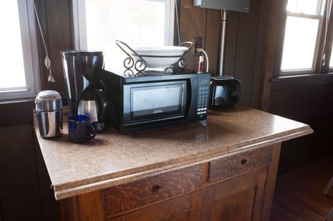 Kitchen countertop with microwave, toaster, coffee maker.