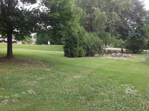 large yard with a fire pit on the side of the house