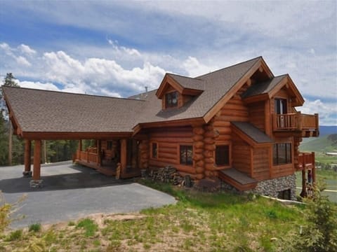Northern view of log house and covered drive.