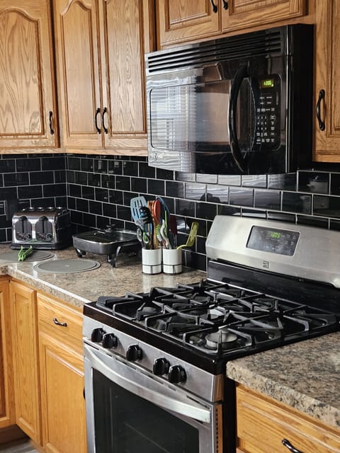 Kitchen area with micro wave, gas stove, electric skillet and toaster