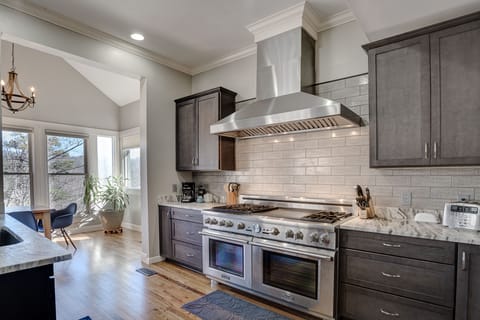 Kitchen featuring 60” Thermador gas pro range with griddle and double ovens.