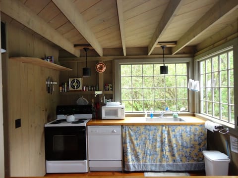 Open kitchen; shelves with dishes, pots, pans, etc. right under camera position