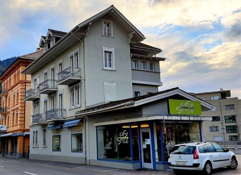 Apartment building, the entrance to the parking is where the white car is drivin