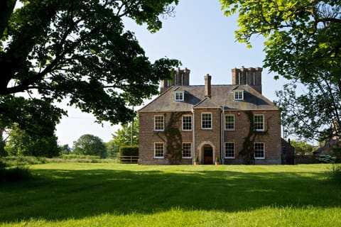 The front northern aspect of the house looking up through the avenue of trees.