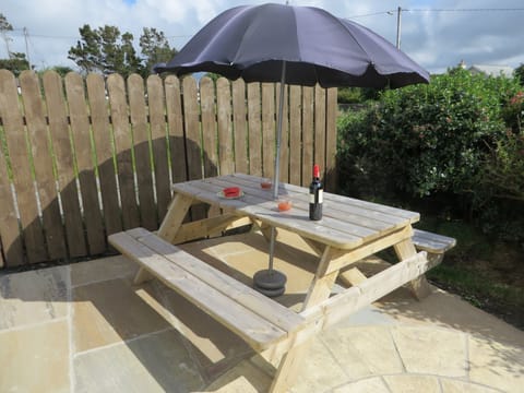 Stone patio with picnic table in a secluded area of the garden.