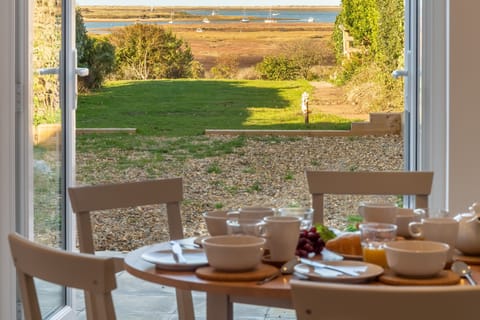 Pebble Cottage, Brancaster Staithe: Dining area with a view to the marshes and sea beyond