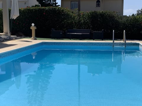 large pool leading to astro turf and outside dining area

