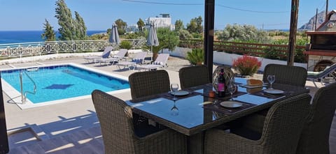 Dining on the poolside terrace with stunning sea views