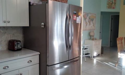 Large new refrigerator, with ice maker and freezer on the bottom.