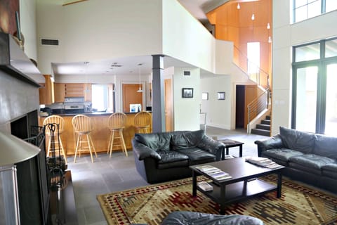Two story living room flooded with natural light opening to full kitchen
