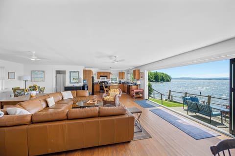 Sun-filled open floor plan with bi-fold door showcasing full lake views.