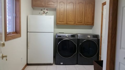 Laundry room with extra refrigerator and commercial size washer and dryer
