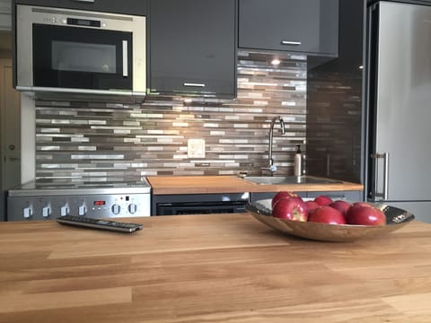 Kitchen includes microwave, dishwasher, fridge, stove and wood-topped island