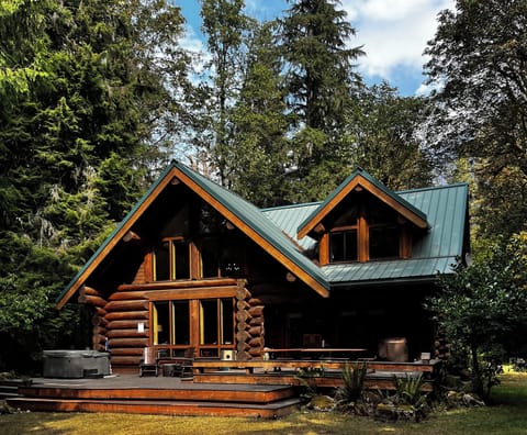 An exclusive hand crafted log cabin on the river surrounded by forest.