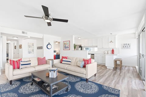 The living area includes leather sofa set, cable TV, and access door to the outdoor deck.
                