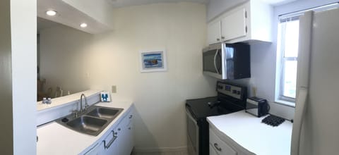 Whirlpool glass top stove & above range microwave in Galley style kitchen