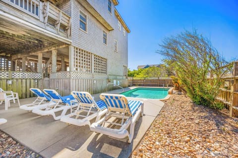Relax on striped loungers by your private pool, surrounded by coastal charm and sunny skies—perfect for soaking up the warmth and unwinding in style.