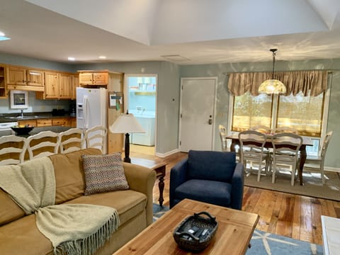 Comfortable open living area with couch and 2 comfortable chairs, open kitchen
