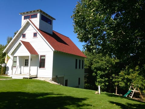 Early summer view of School House. Play set to the right of home.
