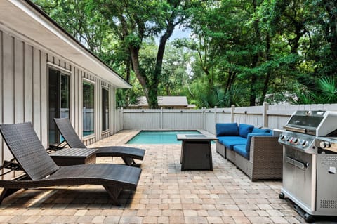 Fenced in backyard with pool, grill, table and loungers