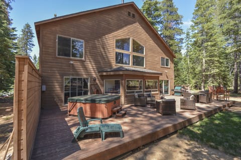 Back of the home - equipped with a hot tub, grill and outdoor furnishings