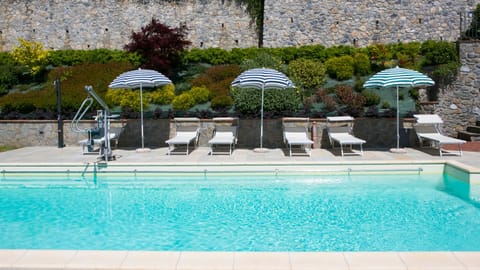 12 x 5 metre pool with sun loungers surrounded by well tended garden