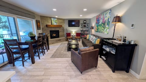 BC West Condo V-1 living room with gas fireplace and patio w/ propane BBQ grill