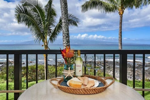 Intimate oceanview balcony — sip wine and savor cheese with tropical blooms and a stunning coastal backdrop.
